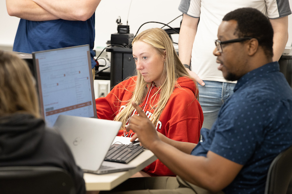 male advisor working with female student at a computer