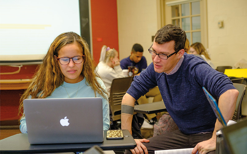 Miami professor works with a student in the classroom