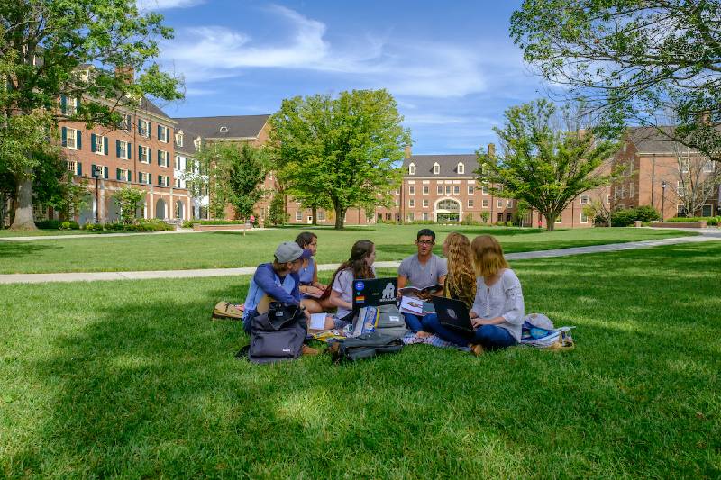 Students walking by the bronze campus hub on their way to class