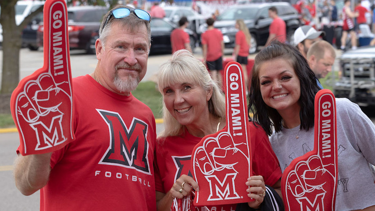 A Miami family, each person wearing a Go Miami foam hand