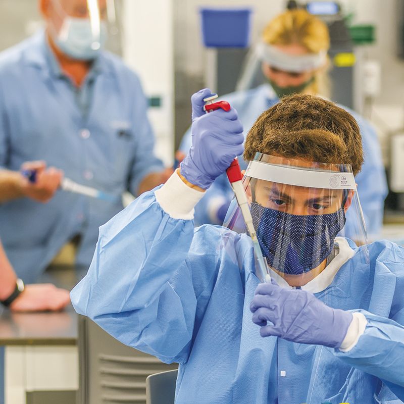 几名学生在实验室用移液管进行实验。