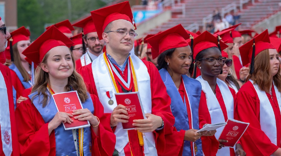 Miami graduates at commencement wearing red robes