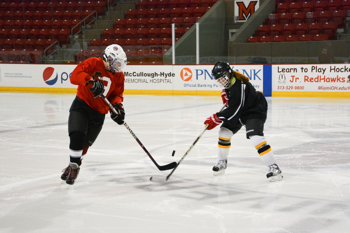 2 club hockey players fighting over puck