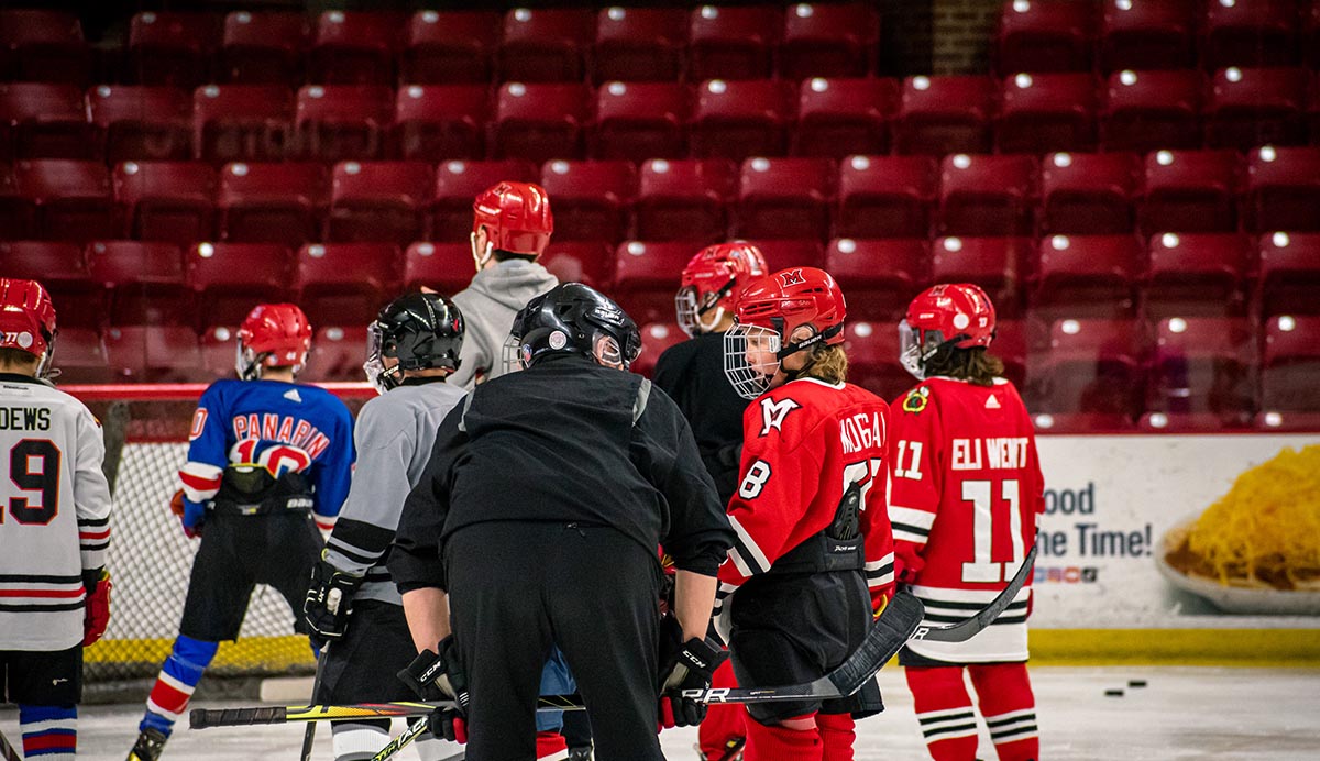 coach teaching miami youth hockey player