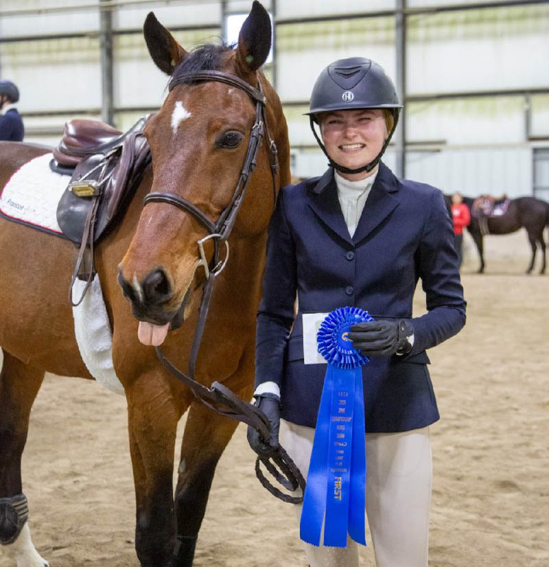 Annika Nyberg with her horse holding a first place ribbon