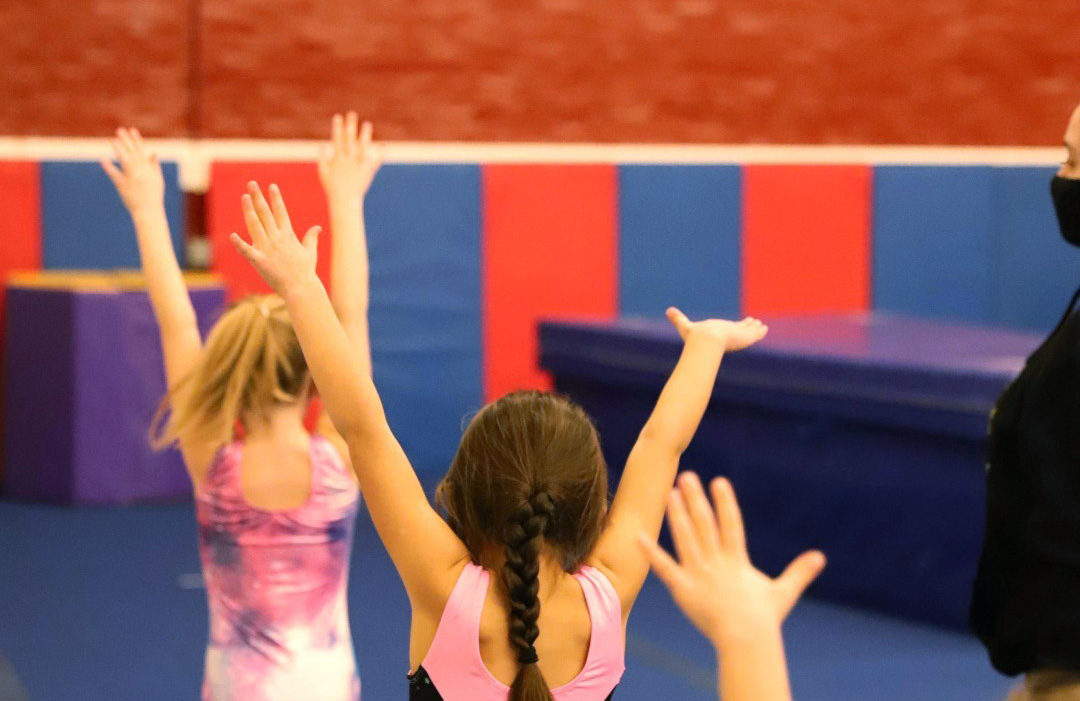 Children posing at the end of a routine on the gymnasium floor