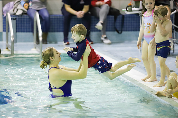 teacher helping child swim