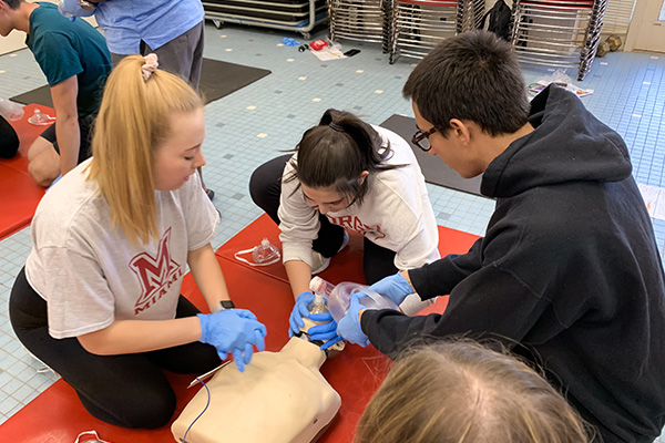 group performing cpr on test dummy