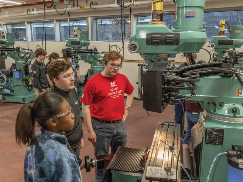 3 students from Miami University and Butler Tech using a piece of equipment at the Advanced Manufacturing Workforce and Innovation Hub.