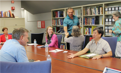 Inaugural alumni advisory participants greeting each other in the Scripps Gerontology Center library