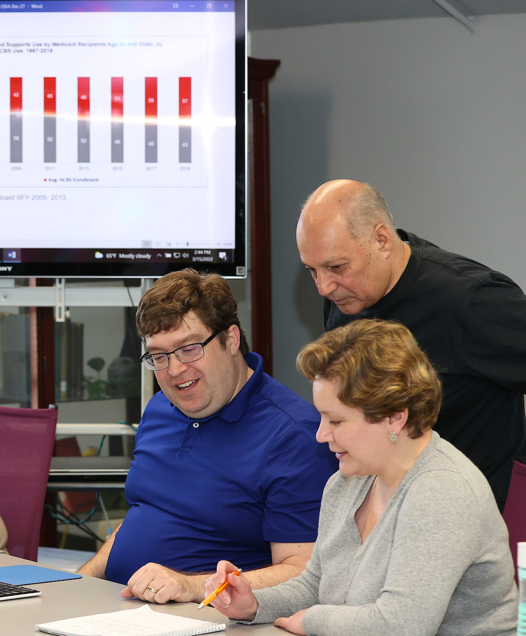 Researchers sitting around Ohio population maps. 