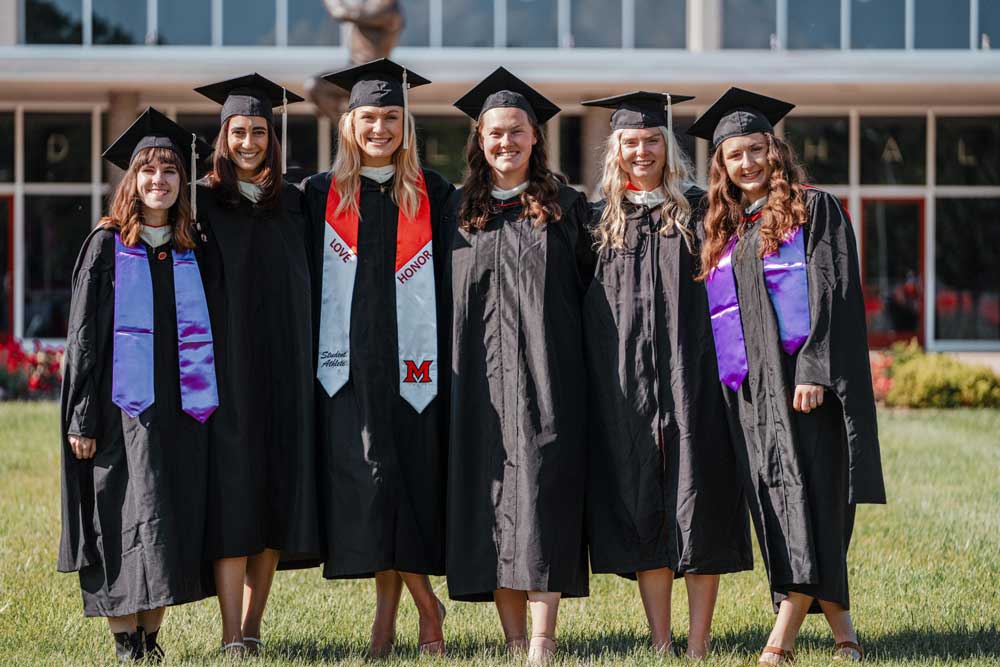 Six students in graduation gowns.