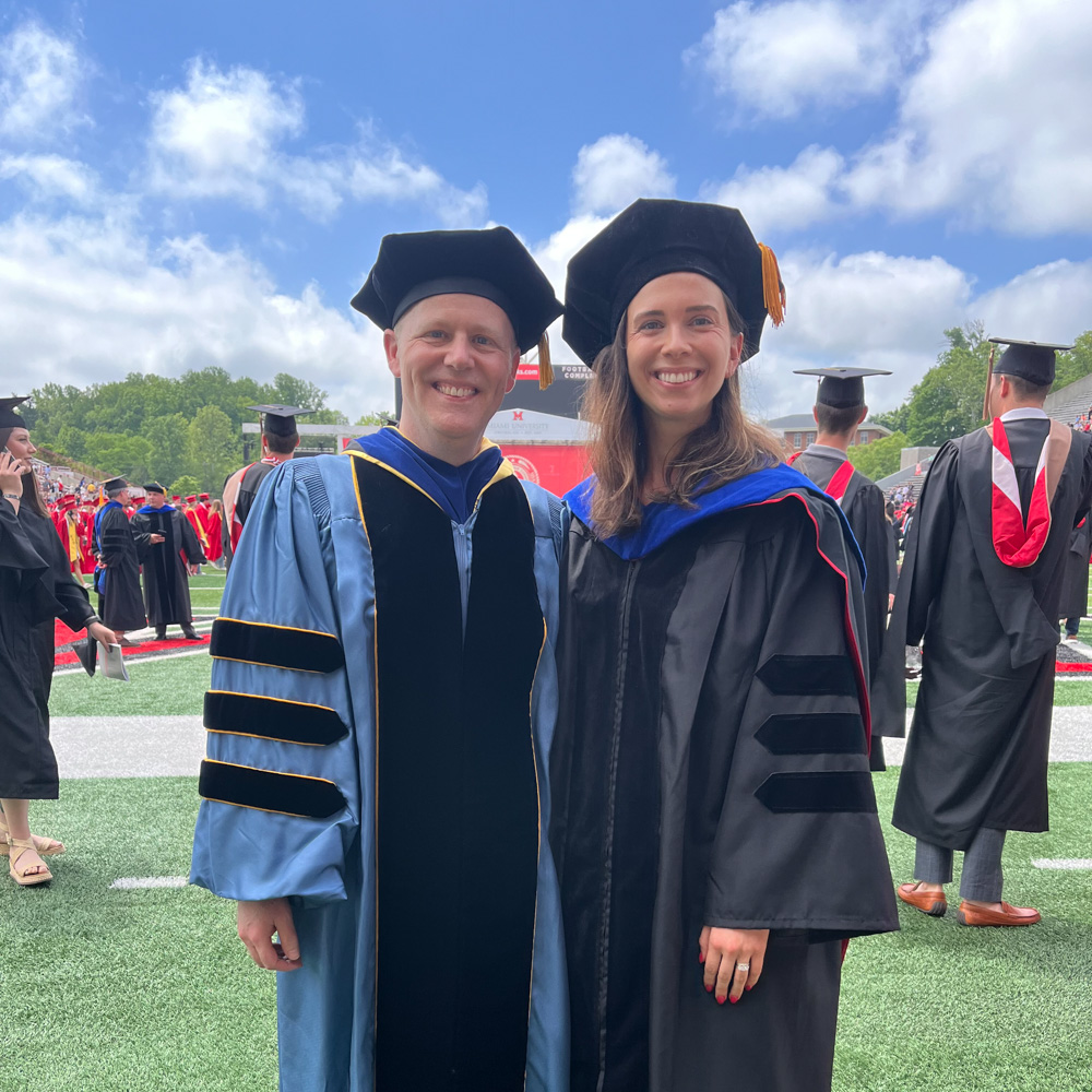 Director of Graduate Studies and Associate Professor Jonathon Vivoda with Miranda Kunkel, recent doctoral graduate, both in their graduation robes and caps. 