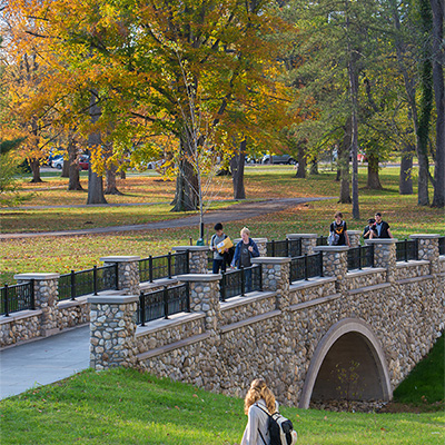students walking across a bridge on western campus