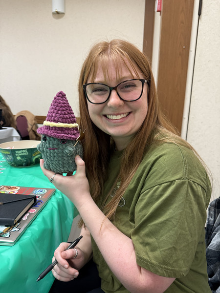 Miami student Sydney Davidson holding up a crotched frog with a purple wizard hat.