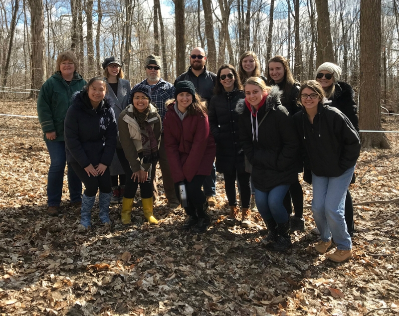 Group posing for photo in the woods