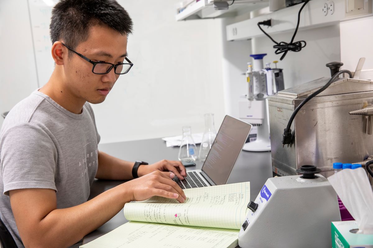 Microbiology student reviewing notes in a lab