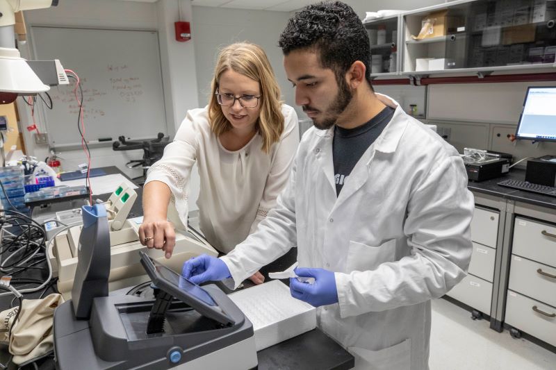 student working in a Chemistry lab with an instructor