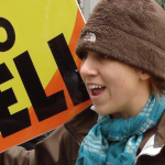 A member of the Westboro Baptist Church holds up signs with confrontational religious messages