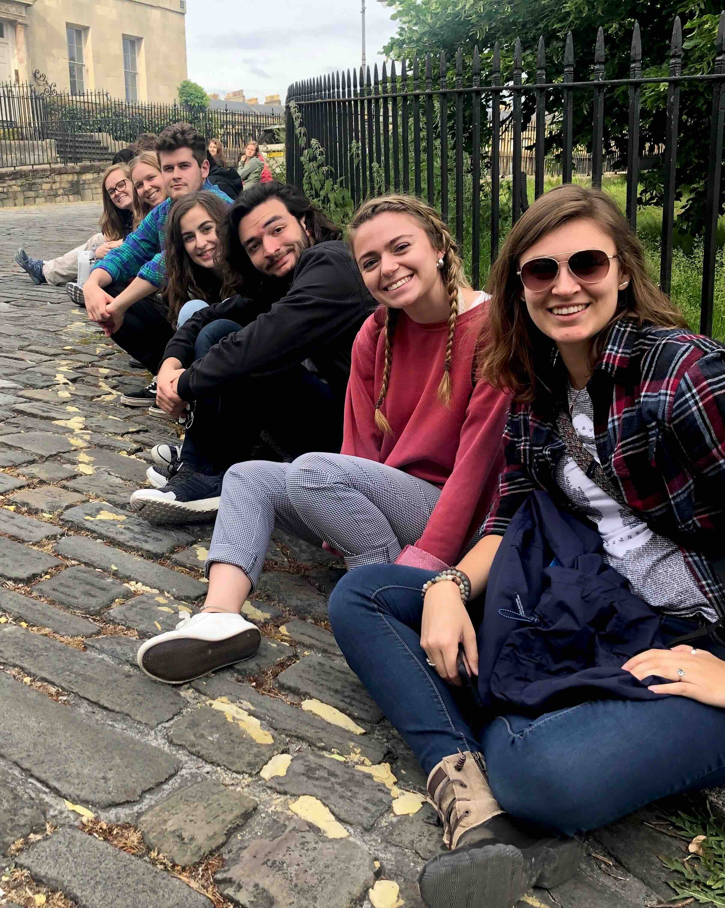 Students sitting on curb of street in Europe