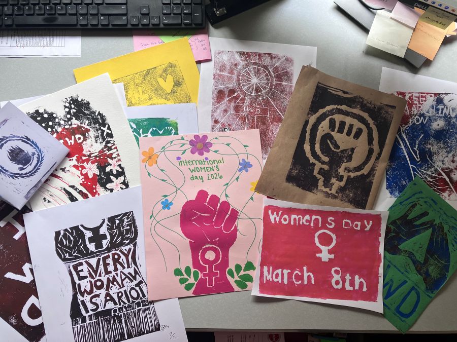 Computer keyboard sits at the top of the image. The rest of the photo are different women's day and international women's day fliers.