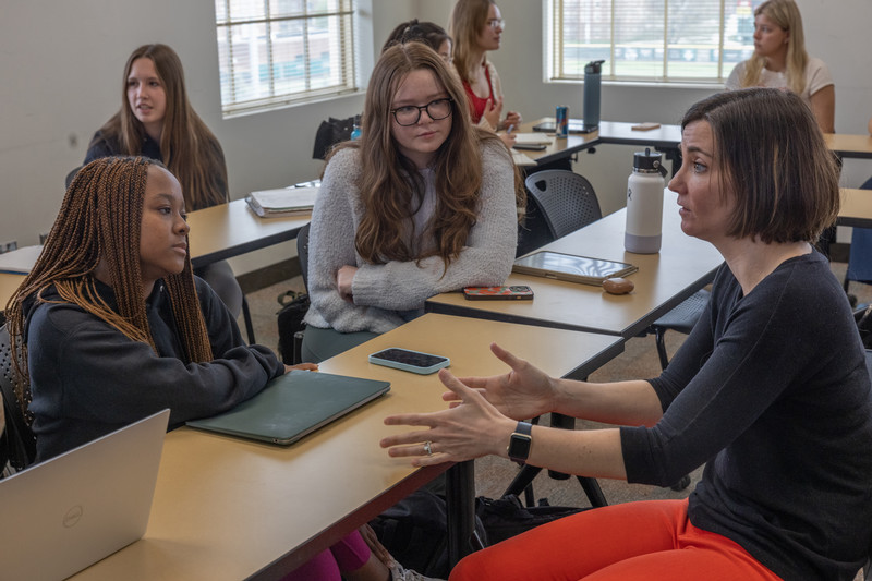 professor and students at table