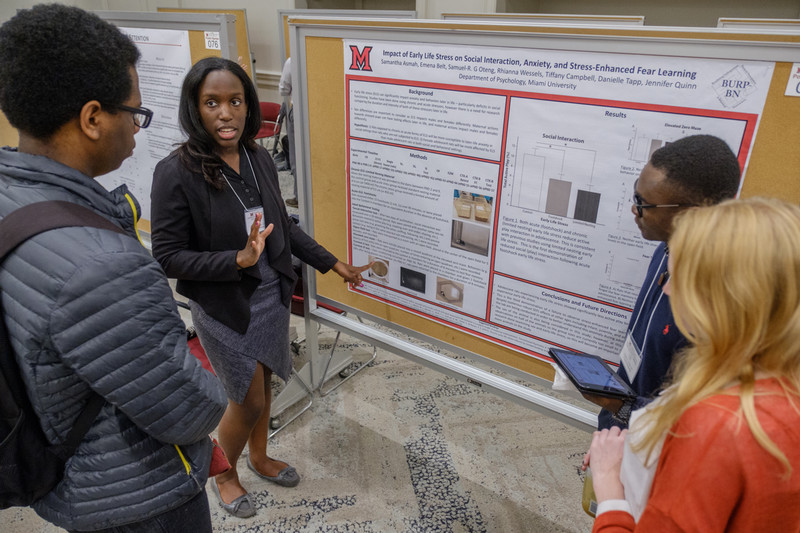 students presenting a research poster