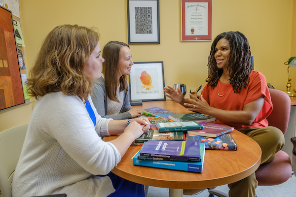 Professor Amber Franklin at a table with 2 students