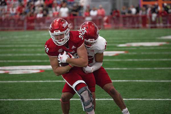 Two Miami University football players scrimmage.
