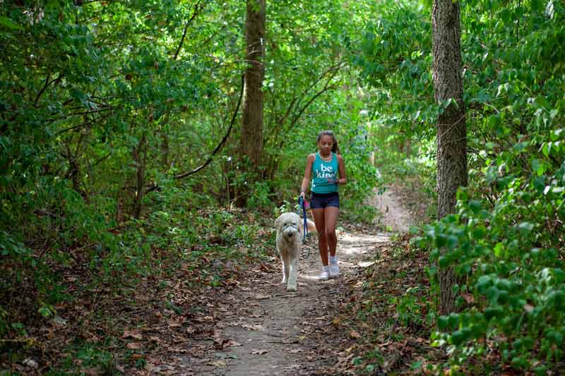 female student hiking with dog