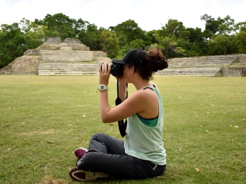 A student taking a photo while sitting on the ground