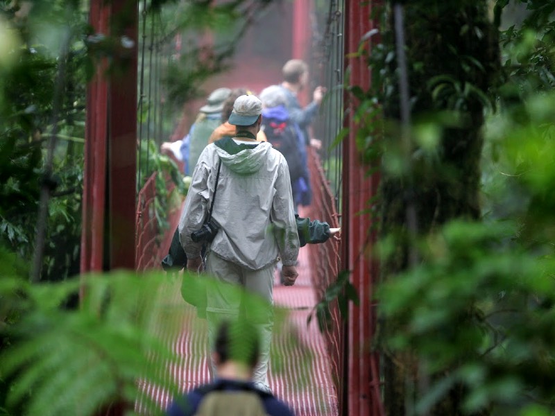 A group of students crossing a red bridge