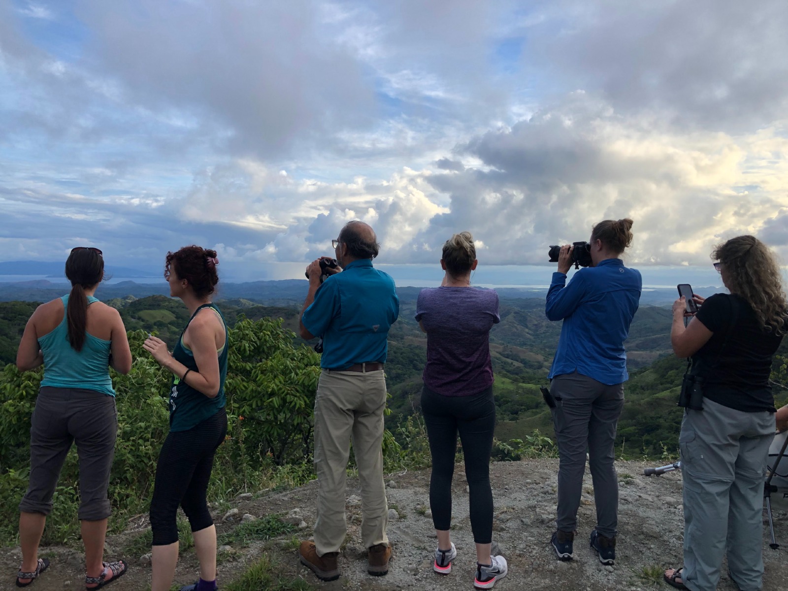 A group of students looking out at the valley and taking pictures.