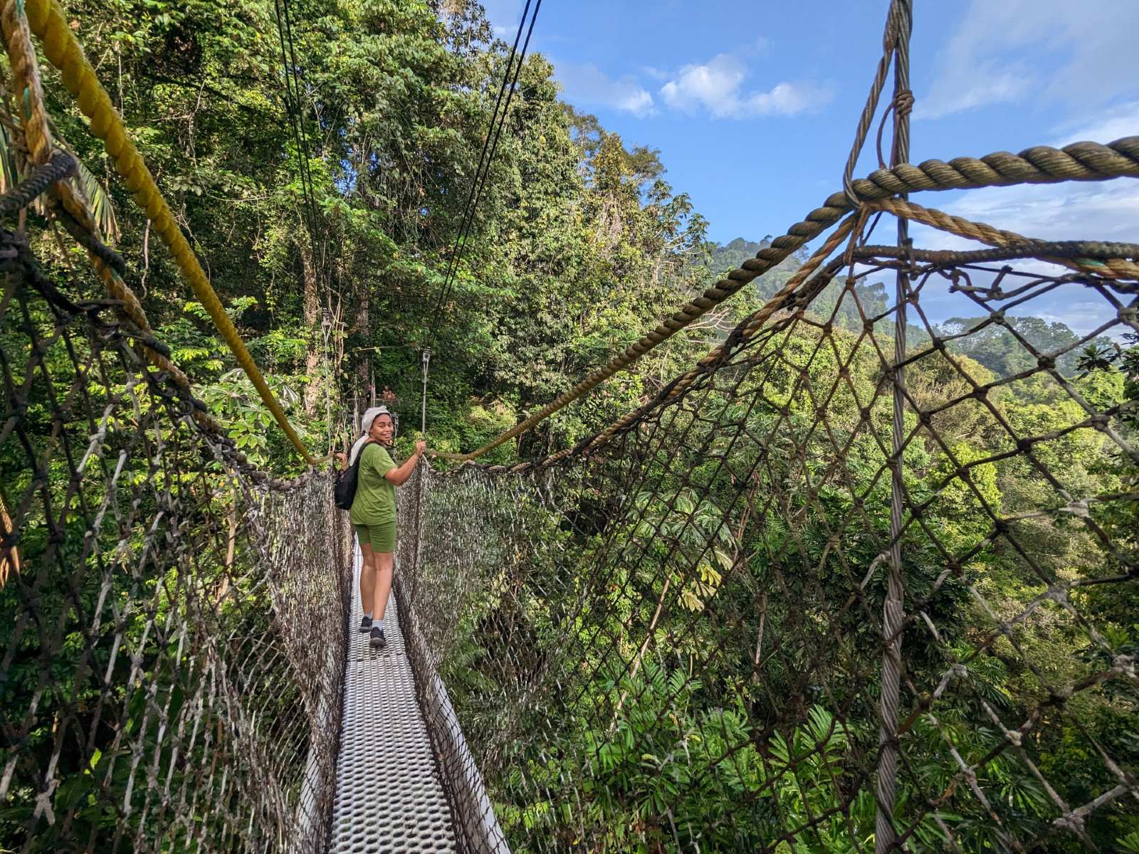 A student standing on a rope bridge.