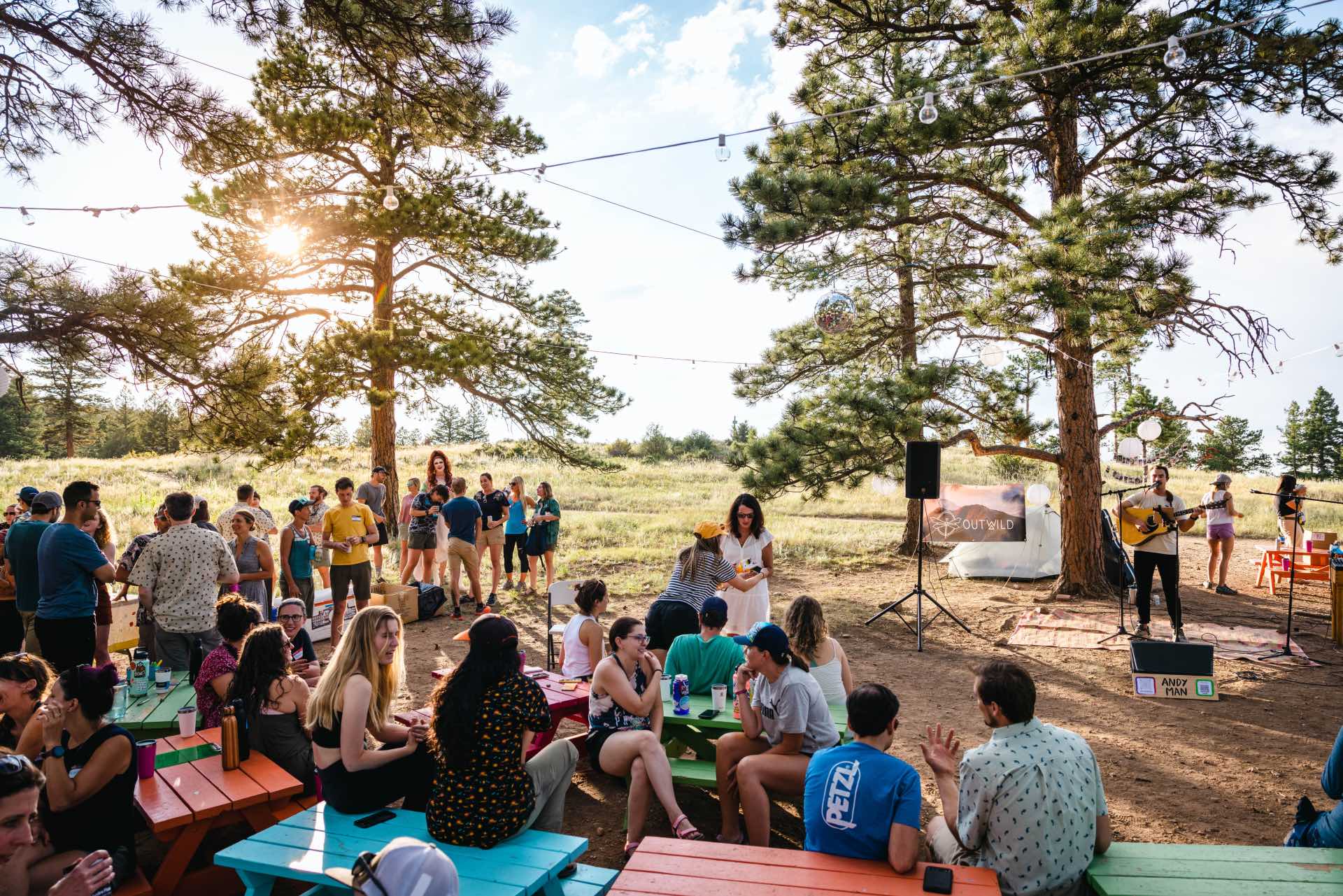 Students sitting outside in picnic benches.