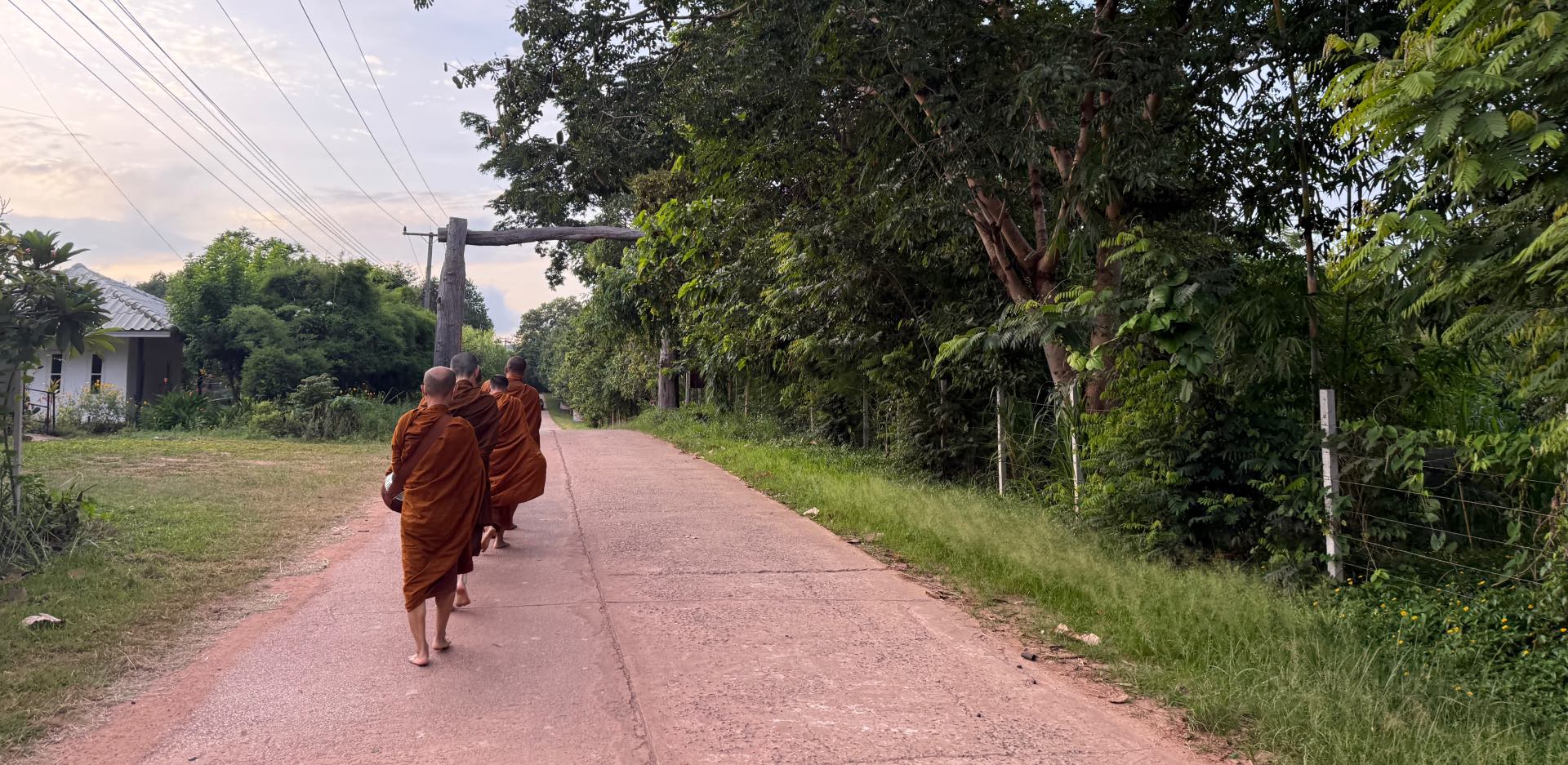 Monks walking down a dirt road.