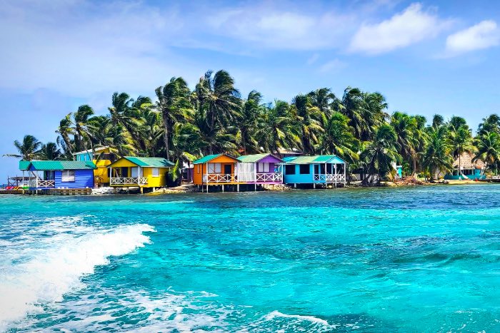 Colorful huts on an island surrounded by very blue waters.