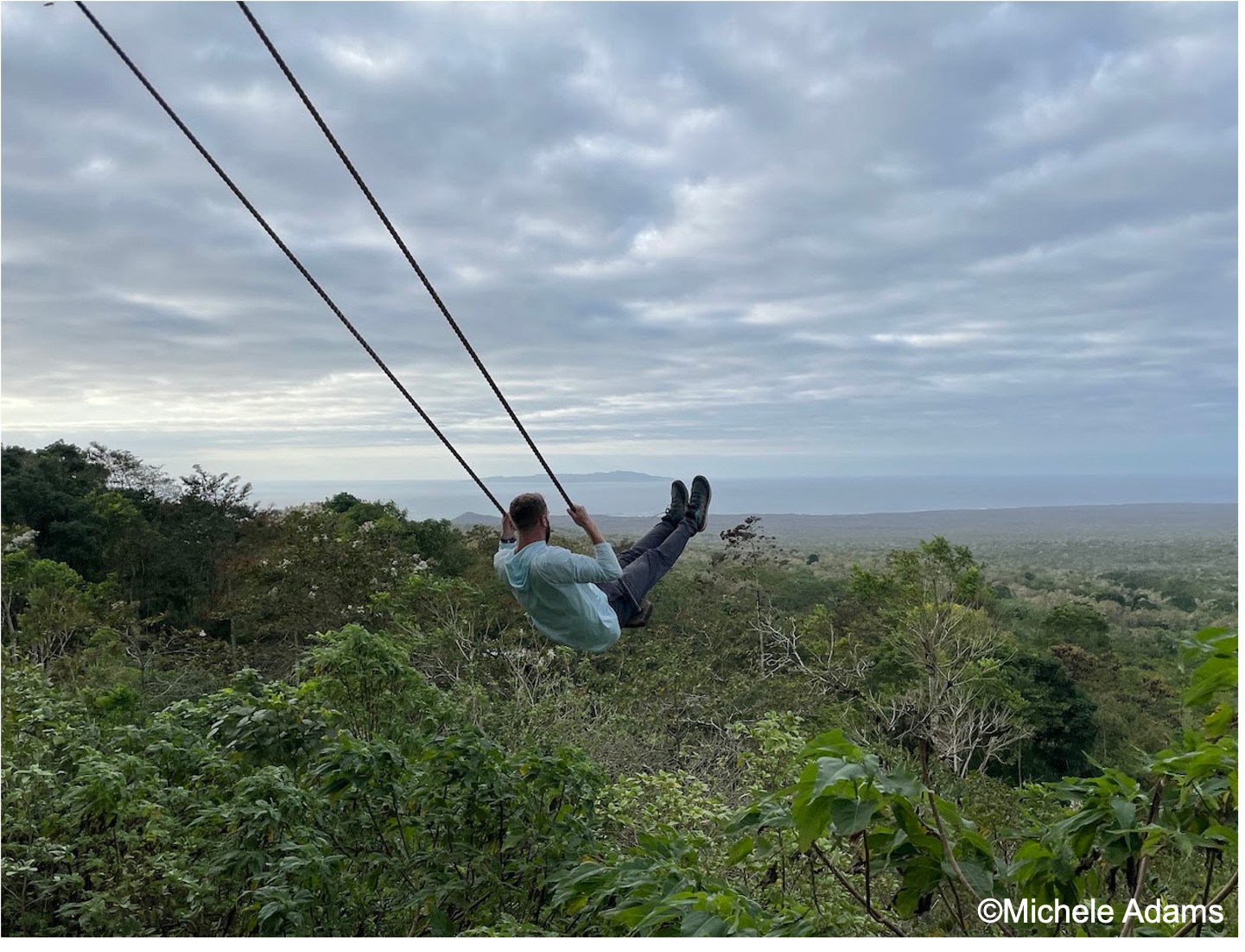 man swinging over clif