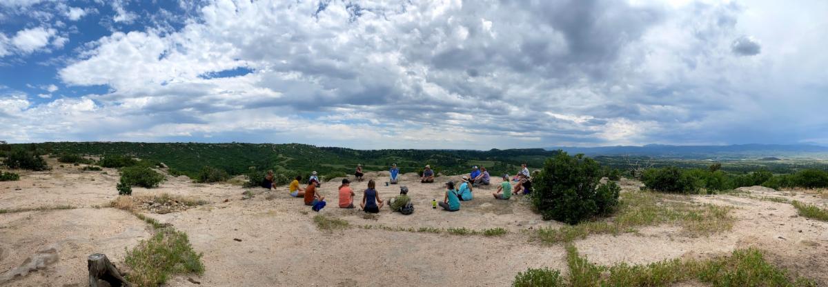 Students sitting in a circle on the ground