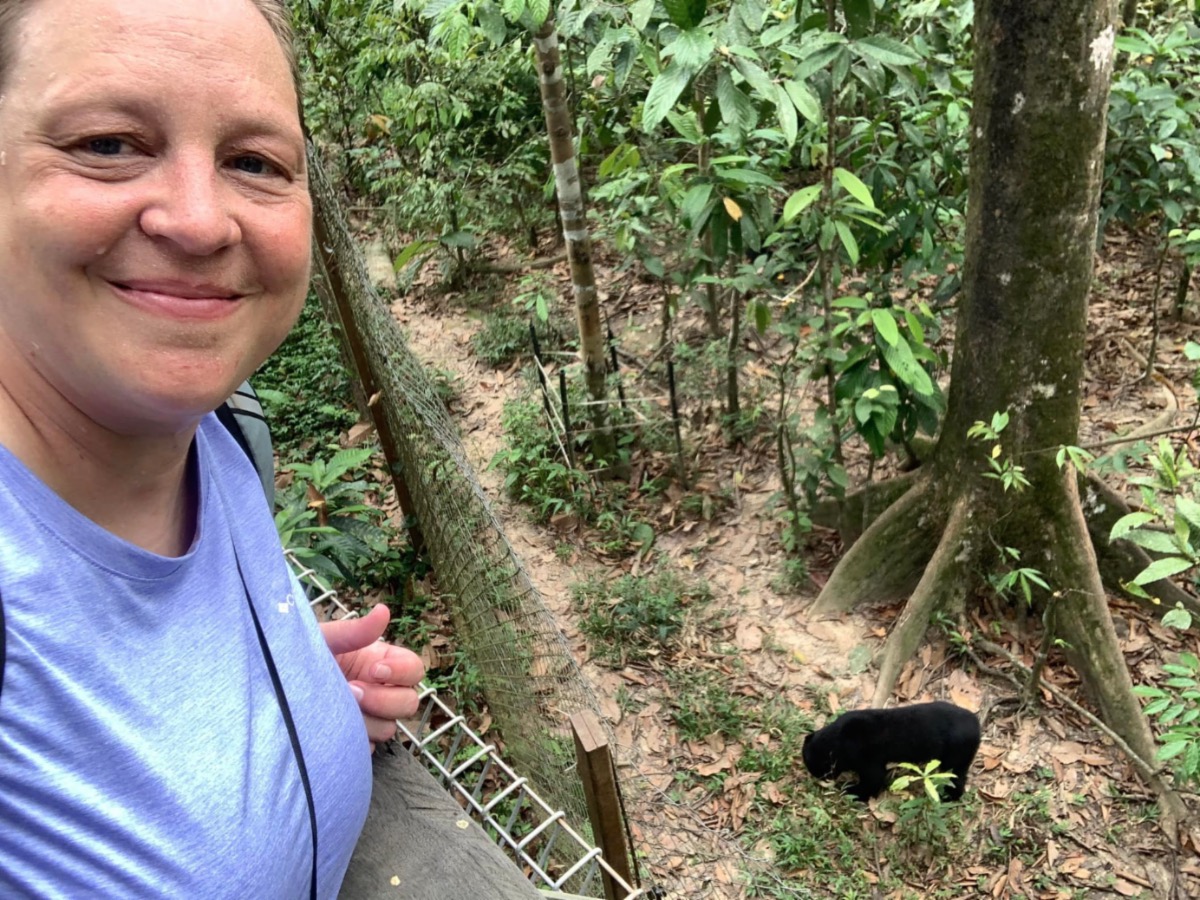 A student looking down at a black bear.