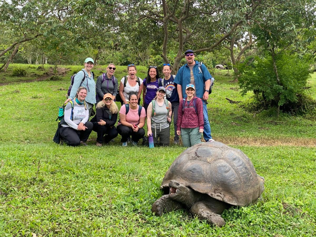Students standing next to a giant tortoise