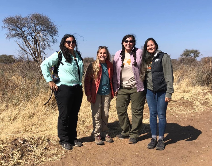 Four students smiling to camera.