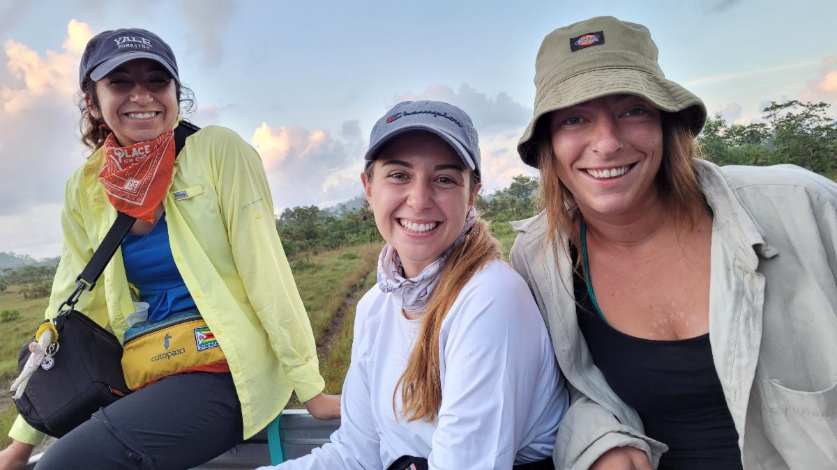 Three students smiling to camera.