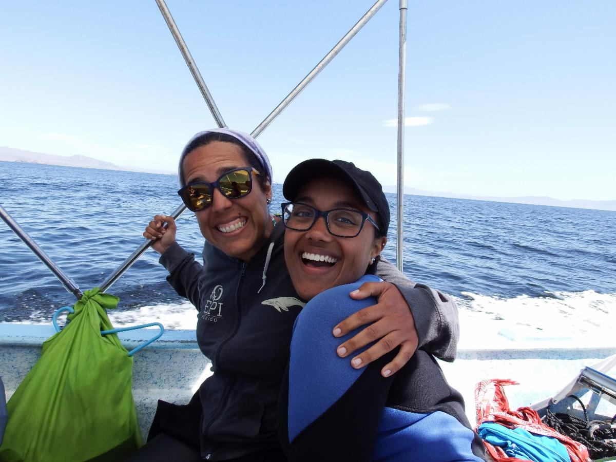 Two students on a boat smiling to camera.