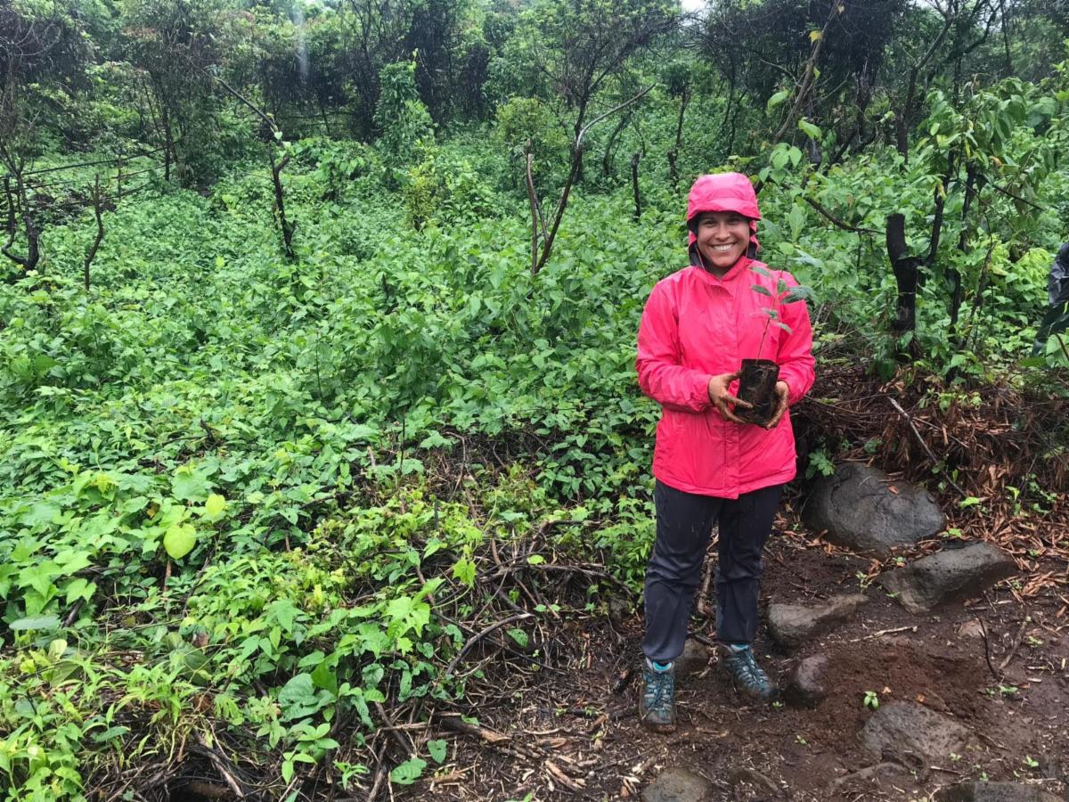 A student in the rain smiling to camera.