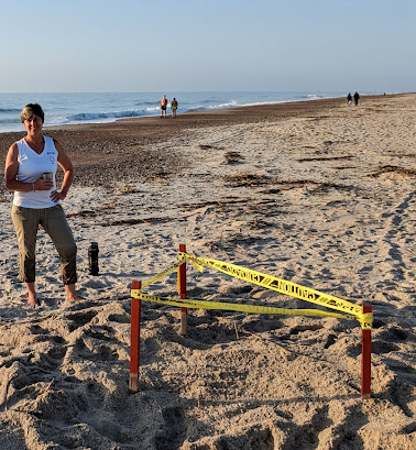 Rhin James standing on a beach next to a sectioned off part of sand.