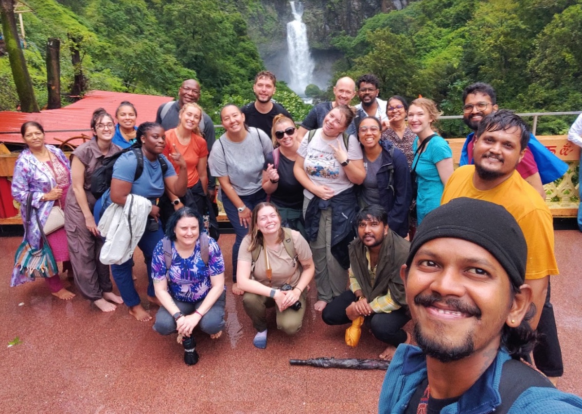 A group photo in front of a waterfall.