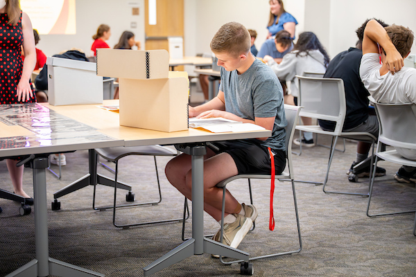 male student writing in a lab