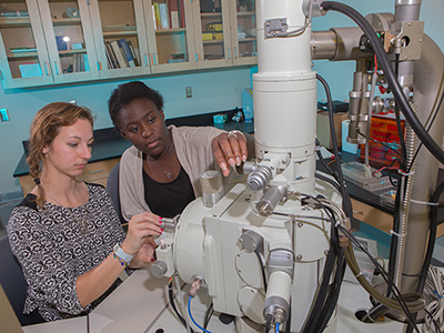 Students Maeva Metz (left) and Wetlyne Wettee load samples into the JEOL JSM-840 SEM.