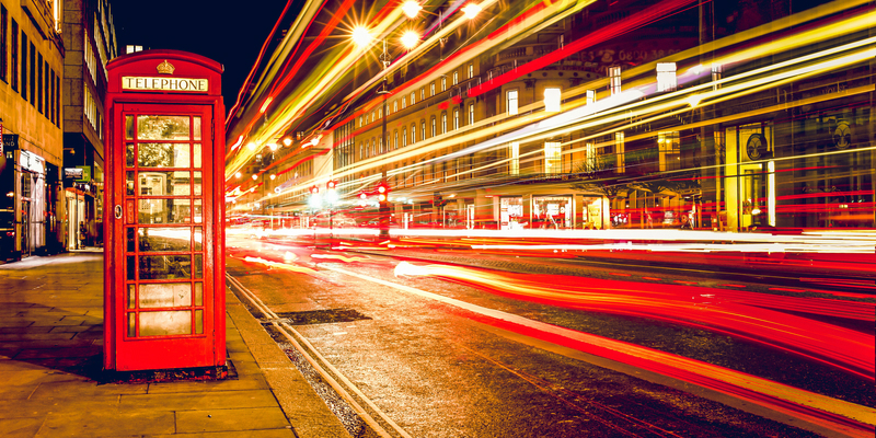 Streets of London at night with a telephone booth in foreground